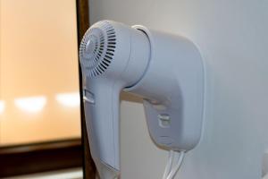 a white hair dryer hanging from a wall at Jagerhof in Râşnov