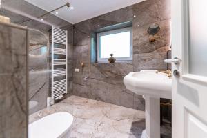 een badkamer met een wastafel, een toilet en een douche bij Juwel am Meer - Achat in Bad Zwischenahn