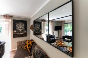 ein Wohnzimmer mit einem Sofa und einem großen Spiegel in der Unterkunft Juwel am Meer - Achat in Bad Zwischenahn