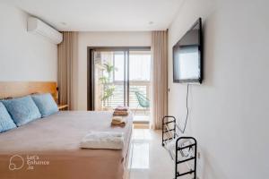 a bedroom with a bed and a flat screen tv at PRESTIGE GHANDI - Studio luxueux & cosy avec terrasse aménagée in Casablanca