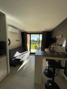 a living room with a bed and a desk and a table at Appt Golfe de Saint-Tropez proche de la mer climatisé in Grimaud