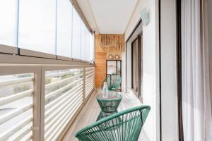 a balcony with two green chairs on it at PRESTIGE GHANDI - Studio luxueux & cosy avec terrasse aménagée in Casablanca