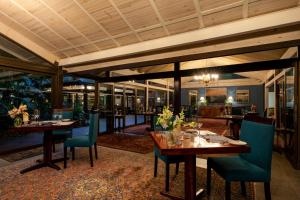 a dining room with tables and chairs in a restaurant at Prana Lodge in Chintsa