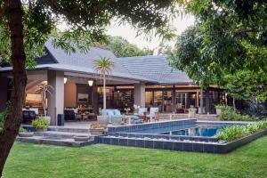 a house with a swimming pool in the yard at Prana Lodge in Chintsa