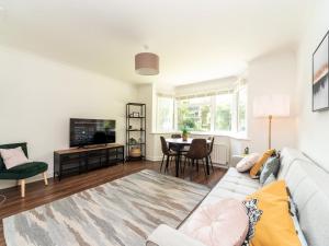 a living room with a couch and a table at Pass the Keys Stylish Apt in quiet cul de sac in Surbiton