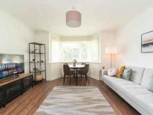 a living room with a couch and a table at Pass the Keys Stylish Apt in quiet cul de sac in Surbiton