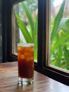 a drink sitting on a table in front of a window at ĐÔNG ĐÔ HOTEL Đăk Lăk in Buôn Tâng Mai
