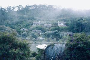 Lat Valley Village في Dankia: مجموعة منازل على تلة فيها اشجار
