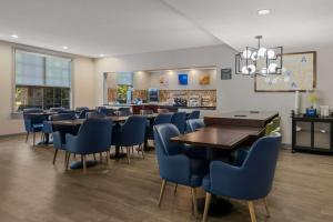 uma sala de jantar com mesas e cadeiras azuis em Comfort Inn Newport News - Hampton I-64 em Newport News