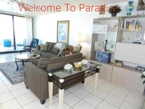 een woonkamer met een bank en een tafel bij "SHERWIN" Coastal Vibes Oceanfront Condominium 301 in Daytona Beach