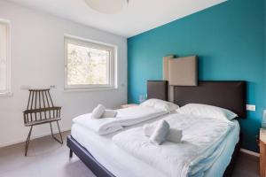 un grande letto in una stanza con una parete blu di Casa tra gli Olivi ad Arco