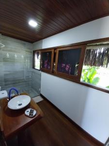 a bathroom with a sink and a mirror at Pousada Refúgio Eça-Porã in Serra Grande