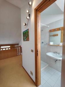 a bathroom with a sink and a toilet and a mirror at Hostdomus - Sansicario C 14 in Cesana Torinese