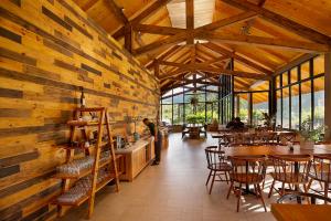 Lat Valley Village في Dankia: مطعم بجدران خشبية وطاولات وكراسي
