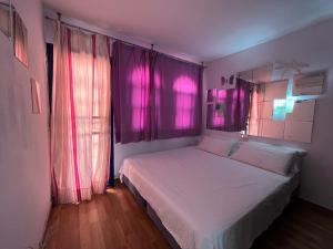 a bedroom with pink lights on the windows and a bed at Bungalow in the sun of Maspalomas with large pool in Maspalomas