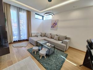 a living room with a couch and a table at Anthracite life & spa Zlatibor in Zlatibor