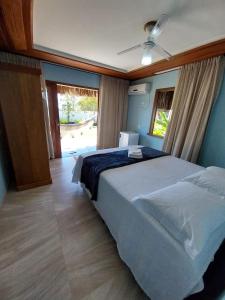 een slaapkamer met een groot bed en een raam bij Pousada Refúgio Eça-Porã in Serra Grande