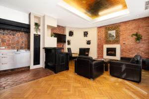 uma sala de estar com mobiliário de couro e uma parede de tijolos em Castello Apartments em Viena