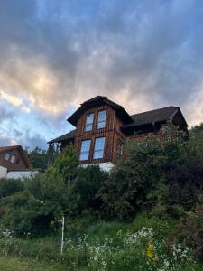 a large wooden house with windows on a hill at Kreischberg-Blick in Lutzmannsdorf