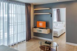 een slaapkamer met een bed en een televisie op een tafel bij O2 Hotel Maesot in Mae Sot