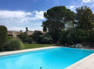 a swimming pool in a yard with a house at La Villa del Sol in Montélimar