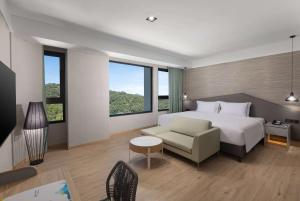 ein Hotelzimmer mit einem Bett und einem Sofa in der Unterkunft Wyndham Sun Moon Lake in Yuchi