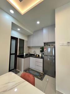 a kitchen with white cabinets and a stainless steel refrigerator at Homestay 3R2B Muci Residensi Zamrud, Kajang 2, Bandar Baru Bangi - non smoking homestay in Kajang