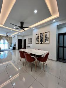 uma sala de jantar com uma mesa branca e cadeiras vermelhas em Homestay 3R2B Muci Residensi Zamrud, Kajang 2, Bandar Baru Bangi - non smoking homestay em Kajang