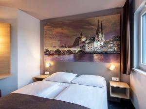 ein Schlafzimmer mit einem großen Gemälde über einem Bett in der Unterkunft B&B Hotel Regensburg in Regensburg