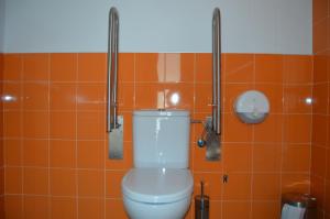 Arroyo de la LuzにあるHostel Divino Moralesのバスルーム(オレンジ色のタイル張りの壁のトイレ付)