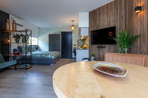een woonkamer met een houten tafel en een woonkamer bij Bed & keuken De Vos in Delden