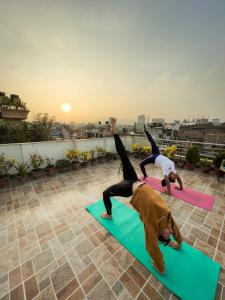 two people doing yoga on mats on a rooftop at Shine Homestay Famille Francophone - Shine Home and Apartment in Kathmandu