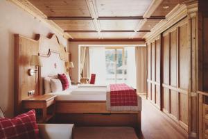 a bedroom with a bed and a large window at Burg Hotel Oberlech in Lech am Arlberg