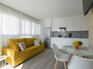 ein Wohnzimmer mit einem gelben Sofa und einem Tisch in der Unterkunft Atenea By CanariasGetaway in Telde