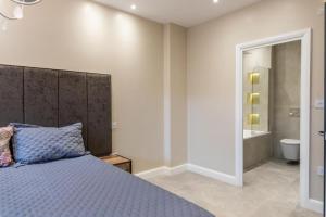 een slaapkamer met een bed en een badkamer bij Beautiful 1-Bed Apartment in Golders Green London in Londen