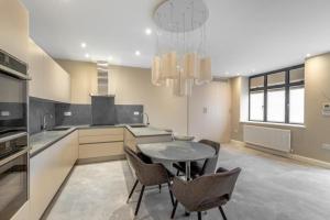 een keuken met een tafel en stoelen in een kamer bij Beautiful 1-Bed Apartment in Golders Green London in Londen