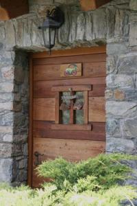 a wooden door of a stone building with a window at B&B Lo Tatà in Fenis