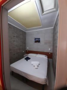 - une petite chambre avec un lit et un miroir dans l'établissement Villaggio Mare Blu, à Vieste