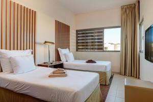 ギーアにあるHerdade dos Salgados, Beach Villa, 3 Suitesのベッド2台と窓が備わるホテルルームです。