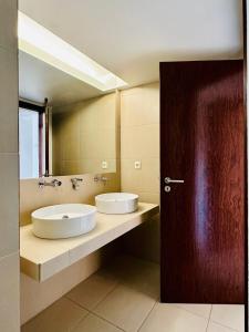 a bathroom with two sinks and a large mirror at Herdade dos Salgados, Beach Villa, 3 Suites in Guia