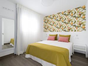 a bedroom with a bed with a painting on the wall at Apolo By CanariasGetaway in Telde