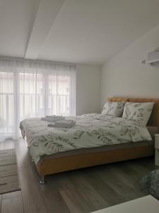a bedroom with a large bed in a room with windows at Studio apartmani Banja Koviljaca in Banja Koviljača