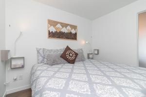 1 dormitorio blanco con 1 cama y una foto en la pared en Chinatown Chic Suite by Iris Properties!, en Victoria
