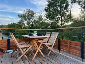 a wooden table and chairs on a deck at Le repos du Wayai in Theux