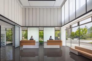 長沙市にあるFairfield by Marriott Changsha Yueluの窓付きの客室で、デスクに座って2名が宿泊できます。