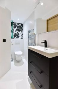 a white bathroom with a sink and a toilet at Charmante maison de village au coeur du Luberon in Cucuron