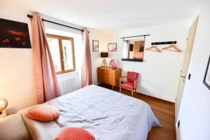 um pequeno quarto com uma cama e uma cadeira em Charmante maison de village au coeur du Luberon em Cucuron