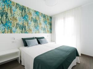 una camera da letto con un letto e carta da parati blu e verde di Zeus By CanariasGetaway a Telde