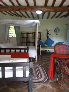 a bedroom with two beds and a table and a chair at Alooma Studio homes in Galu