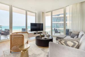 a living room with a couch and a tv at Frank Porter - Al Saadiyat Island in Abu Dhabi